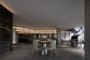 Empty modern restaurant with a large dining table and chairs, surrounded by additional seating and a clean inviting atmosphere