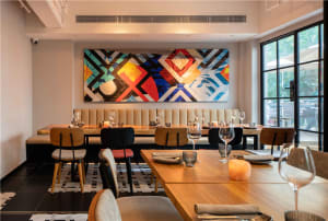Cozy restaurant dining area with wooden tables, wine glasses, and various decorative elements