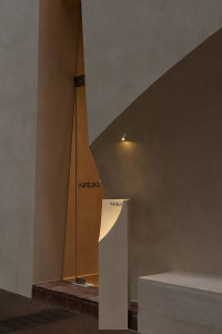 A modern hallway with a concrete wall featuring a sign and a bench, creating a functional and minimalist atmosphere
