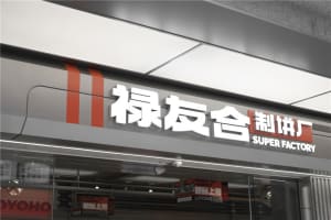 A red and white storefront with a Chinese sign and multiple signs indicating it's a grocery store, surrounded by outdoor lights