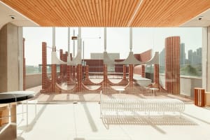 Open indoor space with a brick wall, wooden ceiling, and benches, featuring a mix of modern and traditional elements