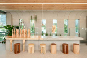 A modern dining space with a wooden table and chairs, surrounded by natural materials and warm lighting