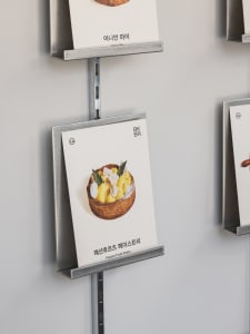 A display of food items in an Asian restaurant, with books on metal racks showcasing menu options
