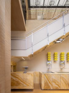 A modern interior space with a staircase made of metal, marble walls, and bottles scattered throughout, conveying a sense of sophistication and refinement
