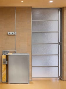 A cozy kitchen with two sinks, a refrigerator, and a door leading to another part of the house