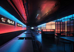A modern Asian restaurant with a dining area featuring multiple tables and chairs, wood, glass, and metal elements, and an inviting atmosphere