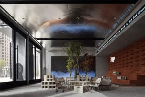 A large room with a dining table and chairs, surrounded by potted plants, creating a comfortable and relaxing atmosphere