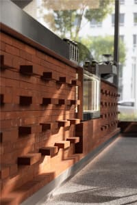 Cozy interior space with a brick wall, a window, and steps leading up to it