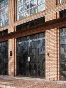 A brown brick building with a unique stained glass door as the focal point, adding an element of intrigue to the composition