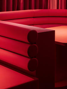 A warm and inviting living area with an orange leather couch, a dining table, and a lively atmosphere