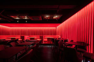 Empty restaurant with red walls, tables, and chairs, creating a warm and inviting atmosphere