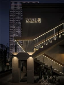 A modern building with a dark and mysterious atmosphere, featuring two staircases with metal railings and illuminated by building lights