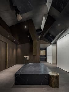 A modern kitchen with a black marble countertop, two sinks, and a contemporary design, giving an elegant and luxurious atmosphere