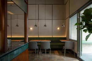 A well-lit dining area with a long table and multiple chairs, surrounded by modern decor and neutral tones