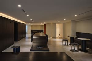 A long wooden table surrounded by chairs in an elegant dining area with a warm and inviting atmosphere