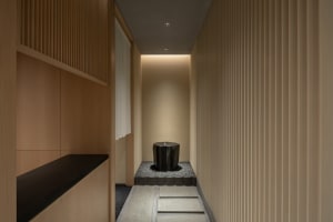 Small bathroom with a black toilet, two sinks, and wood paneling on the walls