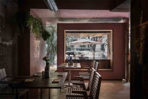 Dining area with tables, chairs, umbrellas, and wine glasses in a restaurant with a relaxed atmosphere