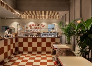Inviting restaurant interior with a counter and chairs, displaying a variety of food items and providing a comfortable dining experience