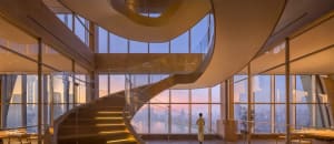 A spiral staircase with metal railings and a modern design, leading upwards in a luxurious setting