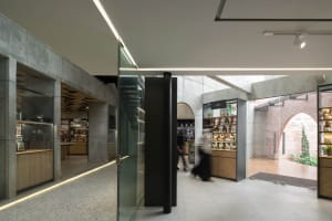 A bright and inviting retail space with a glass wall, natural light, and various decorative items such as bottles, vases, and books