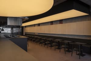 A spacious restaurant with wooden tables and chairs, offering ample seating options for guests