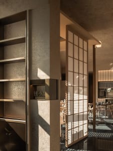 Warm and inviting restaurant interior with wooden floors and walls, multiple dining tables and chairs, and a well-organized layout
