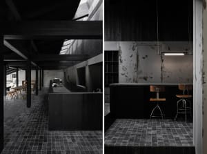 Modern dining and kitchen space with wood and metal accents, dim lighting, and minimal decoration