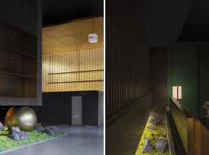 Modern hotel lobby with a large open area featuring a staircase, dining table, chairs, and potted plants, with books scattered throughout, in a contemporary style with clean lines and minimalistic design elements