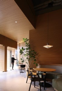 Warm and inviting restaurant interior with wooden walls and floors, a dining table, and potted plants