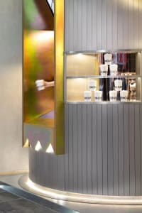 A clean and organized interior space with a large mirror, several cups, and white surfaces