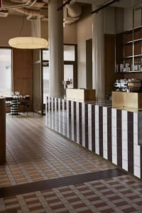 Inviting cafe with a counter and dining table, featuring comfortable seating and various items on display