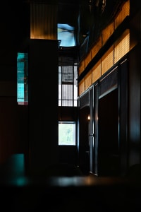 Elegant hotel lobby with a large window, two chairs, and a dining table, featuring natural light and inviting atmosphere