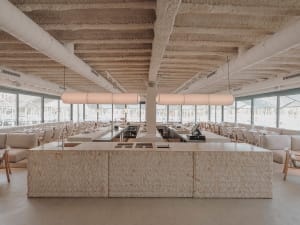 Open restaurant interior with wooden tables and chairs, providing ample seating options for guests in a spacious and inviting atmosphere
