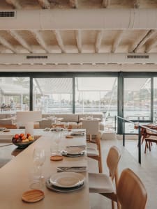 Elegant dining space with a wooden table, set with wine glasses, utensils, and candles, creating a warm and inviting atmosphere
