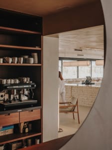 Cozy cafe interior with wooden counters, chairs, and multiple cups, creating a welcoming atmosphere for coffee and beverage service