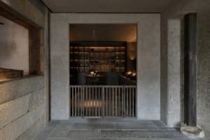 A cozy restaurant interior with a dining table, chairs, bottles, and wine glasses, creating a welcoming atmosphere for socializing and dining