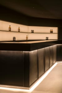A well-stocked bar area with a counter featuring several bottles of liquor and an inviting atmosphere