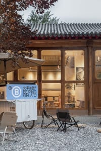 Modern Asian restaurant with dining tables, chairs, and umbrellas outside, creating a comfortable and inviting atmosphere