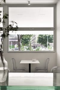 A calm and inviting dining area with a white table surrounded by four chairs and two cups, set for a comfortable meal