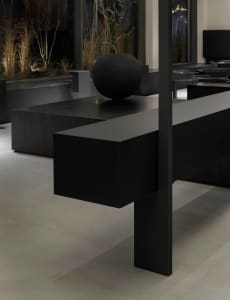 Modern room with a black table, sphere, and benches, featuring a chair and a large window