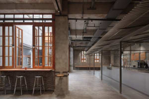 Empty restaurant or bar with a large window, two chairs, and a dining table in a spacious and inviting atmosphere
