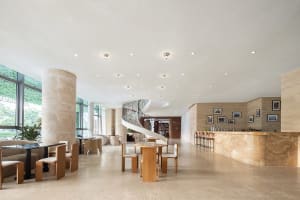 An inviting open lobby with a spiral staircase, chairs, and dining tables, creating a comfortable space for gathering and socializing