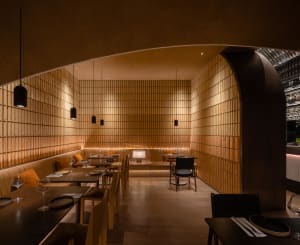 Empty restaurant interior with wooden walls and tables, featuring chairs placed around the dining area to create a calm and inviting atmosphere
