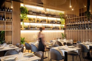 Modern restaurant interior with wooden elements, wine bottles, and a sophisticated atmosphere