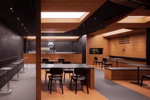 Industrial kitchen area with wooden floors and tables, comfortable seating arrangement with chairs around dining tables