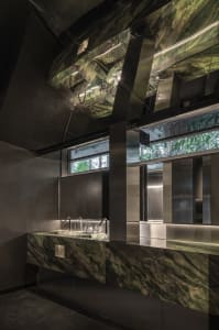 Modern bathroom with two sinks, marble countertops, and warm lighting