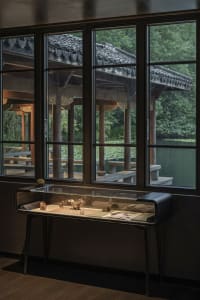A traditional Asian building with a wooden structure and glass window, featuring cozy benches and a culturally rich interior