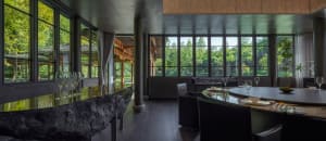 Open living space with couches, dining table, chairs, and large windows allowing natural light to fill the space