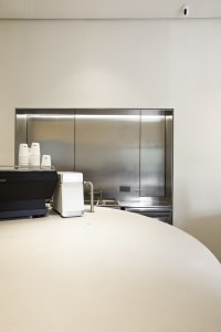 Industrial kitchen scene with a countertop featuring various items, a sink in the background, and a functional atmosphere