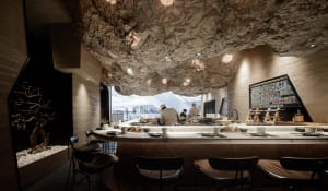 Inviting restaurant interior with a bar, stools, chairs, and dining tables, featuring a mix of hot and cold beverages and meals